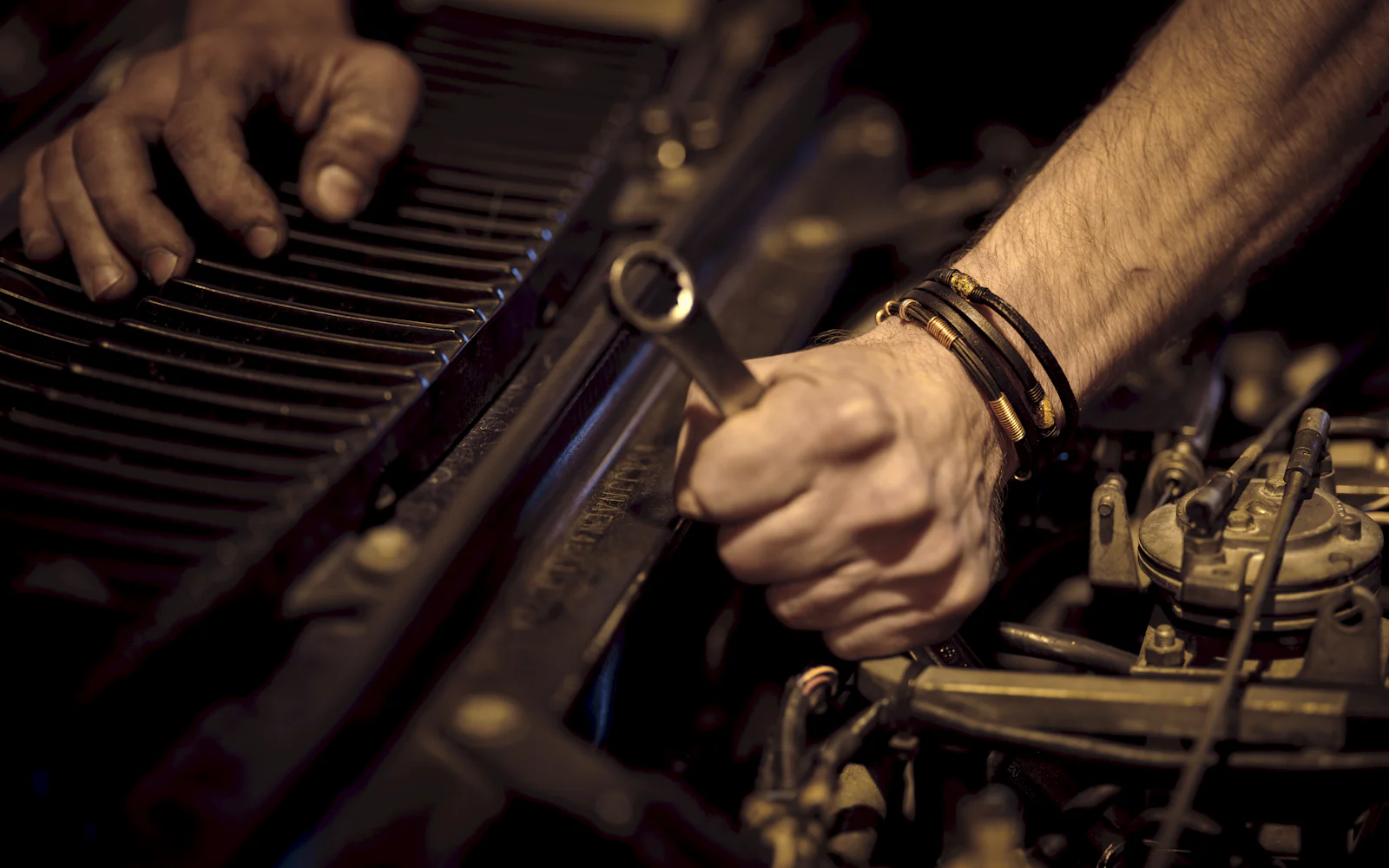 Hands at work on an engine, wrench in hand