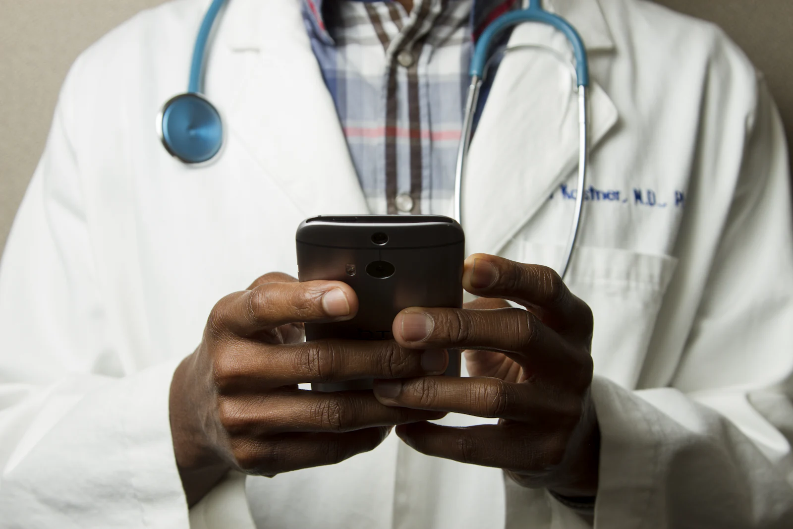 Un médecin en blouse blanche, téléphone en main