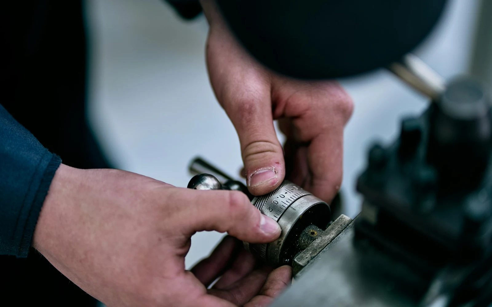 Deux mains ajustant un raccord sur un appareil de chauffage