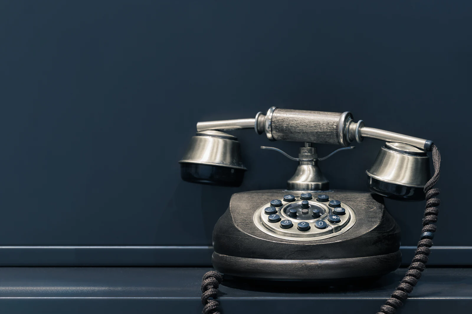 Un téléphone ancien sur un mur bleu nuit
